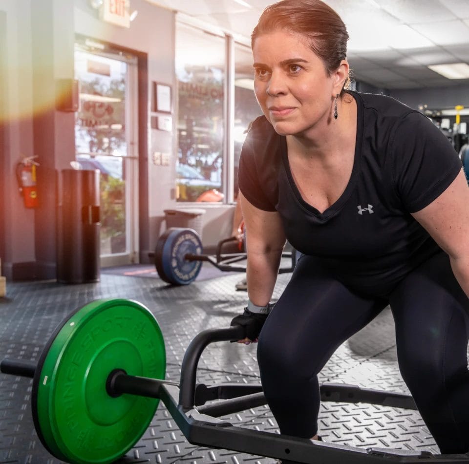 Woman lifting weights at No Limits Fitness