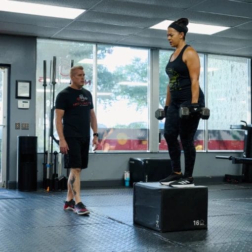 Woman doing step up exercise with dumbbells